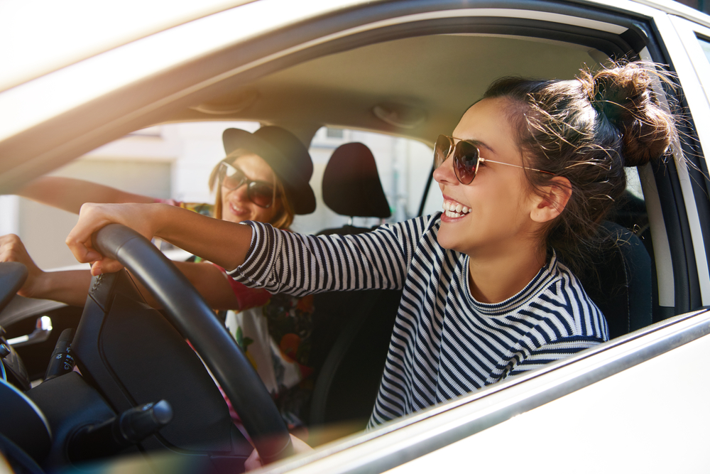Two women laughing and having fun in a car.