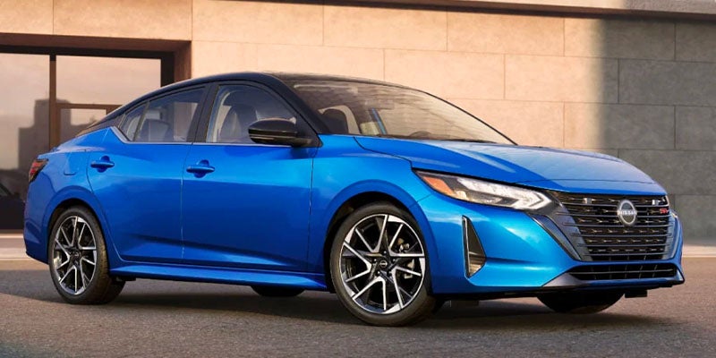 Blue 2025 Nissan Sentra parked in front of a building